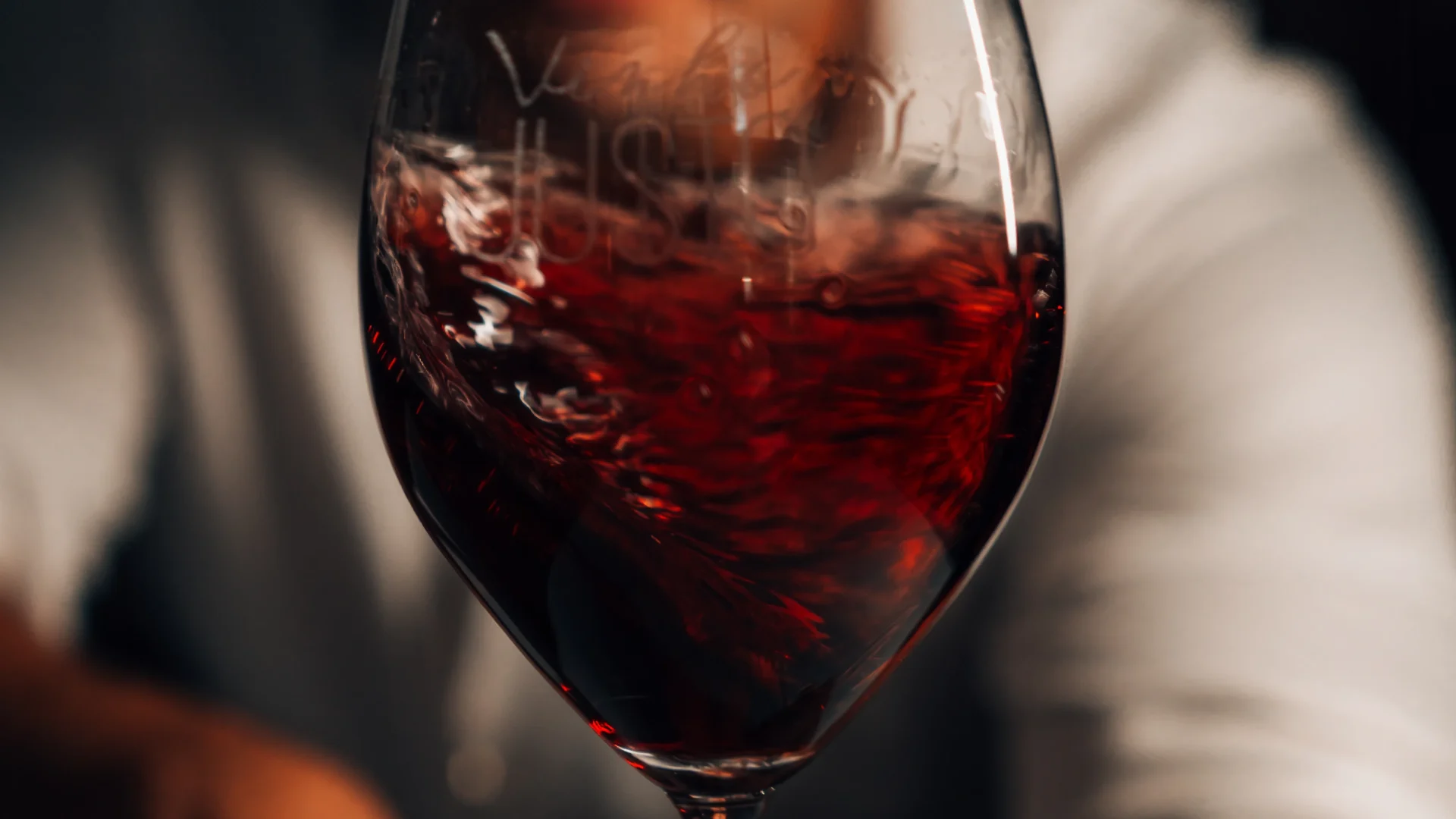 Taça de vinho tinto com a marca Vinho Justo gravada.